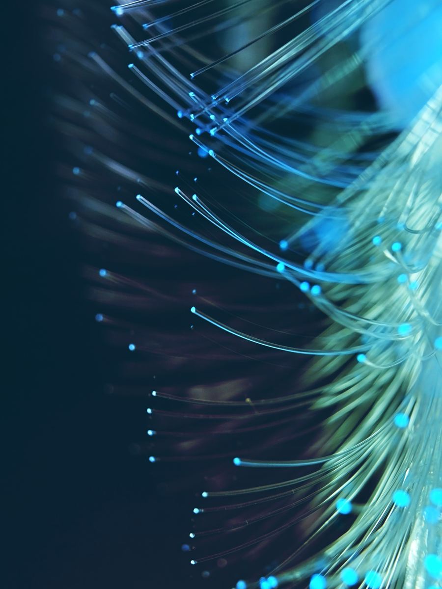 Nahaufnahme von Glasfasern mit leuchtenden Faserenden – Glasfasertechnik von SPLEISS4YOU